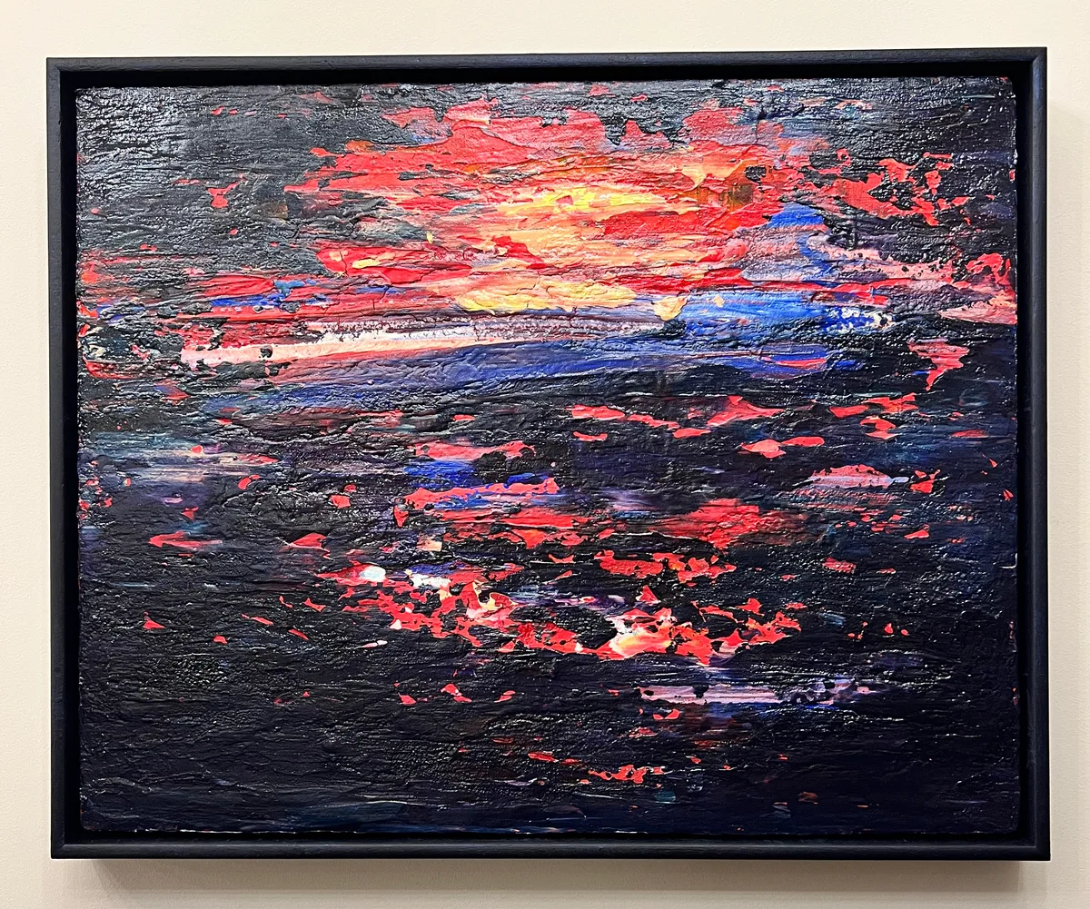 Dawn is Breaking, a textured abstract painting in red, yellow and blue against a dark background in a black frame.