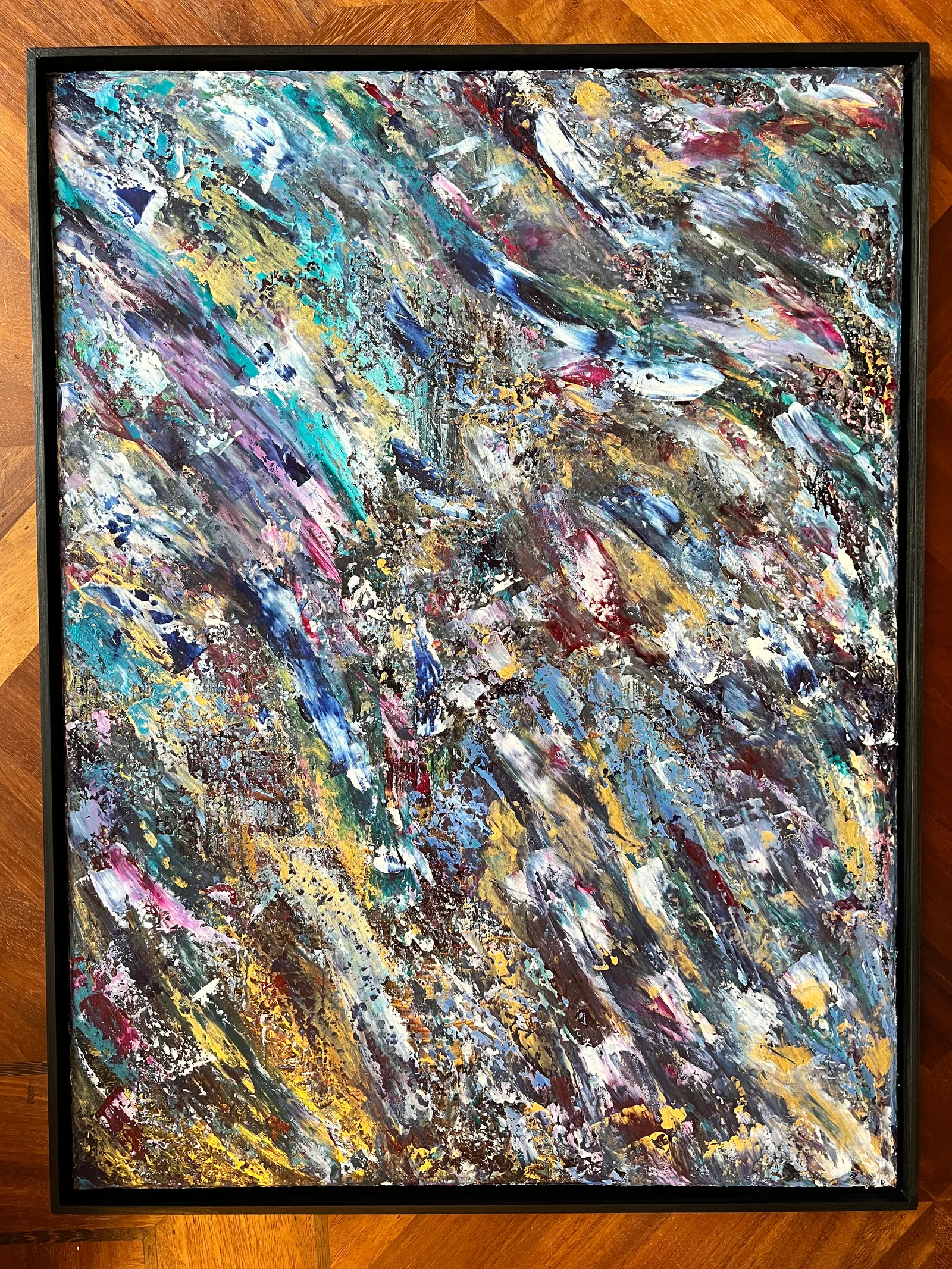 Windward, a textured abstract painting in blue, turquoise, gold and pink in a black shadowbox frame.